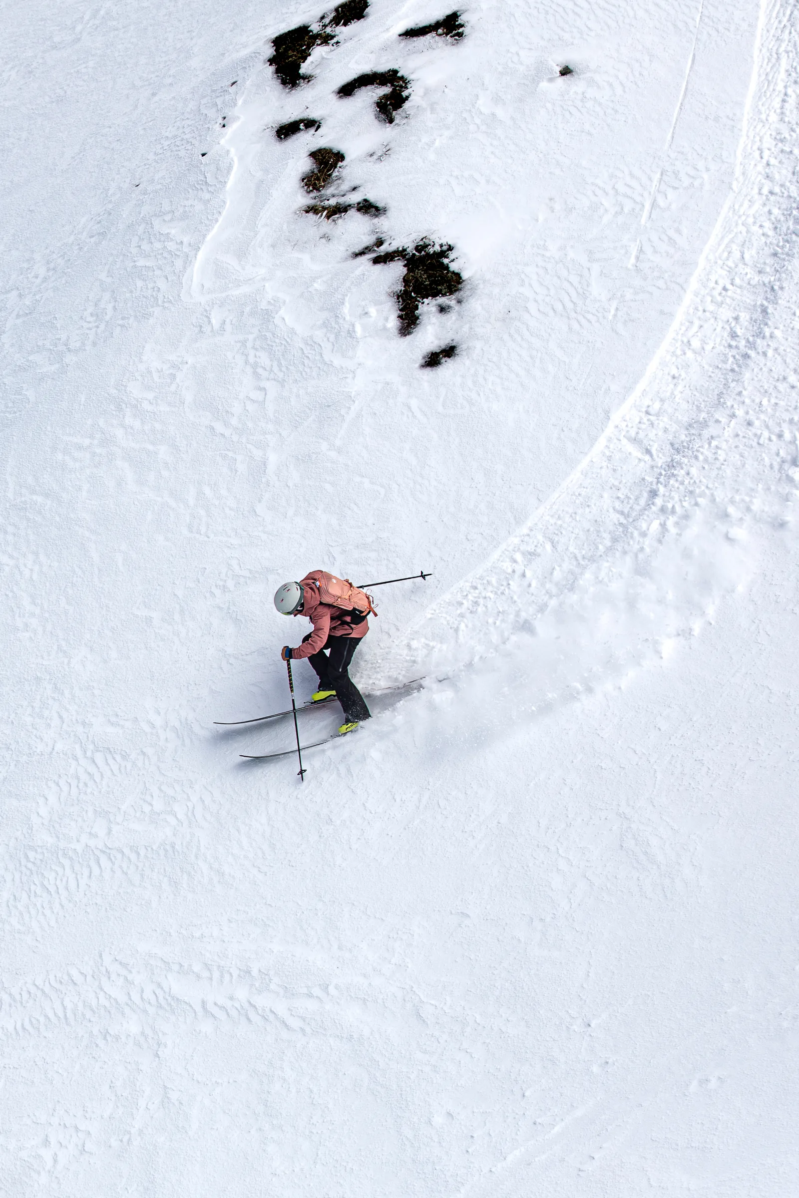 Andrea Limbacher skiing an open powder slope with visible ski tracks in Lenzerheide, viewed from above.