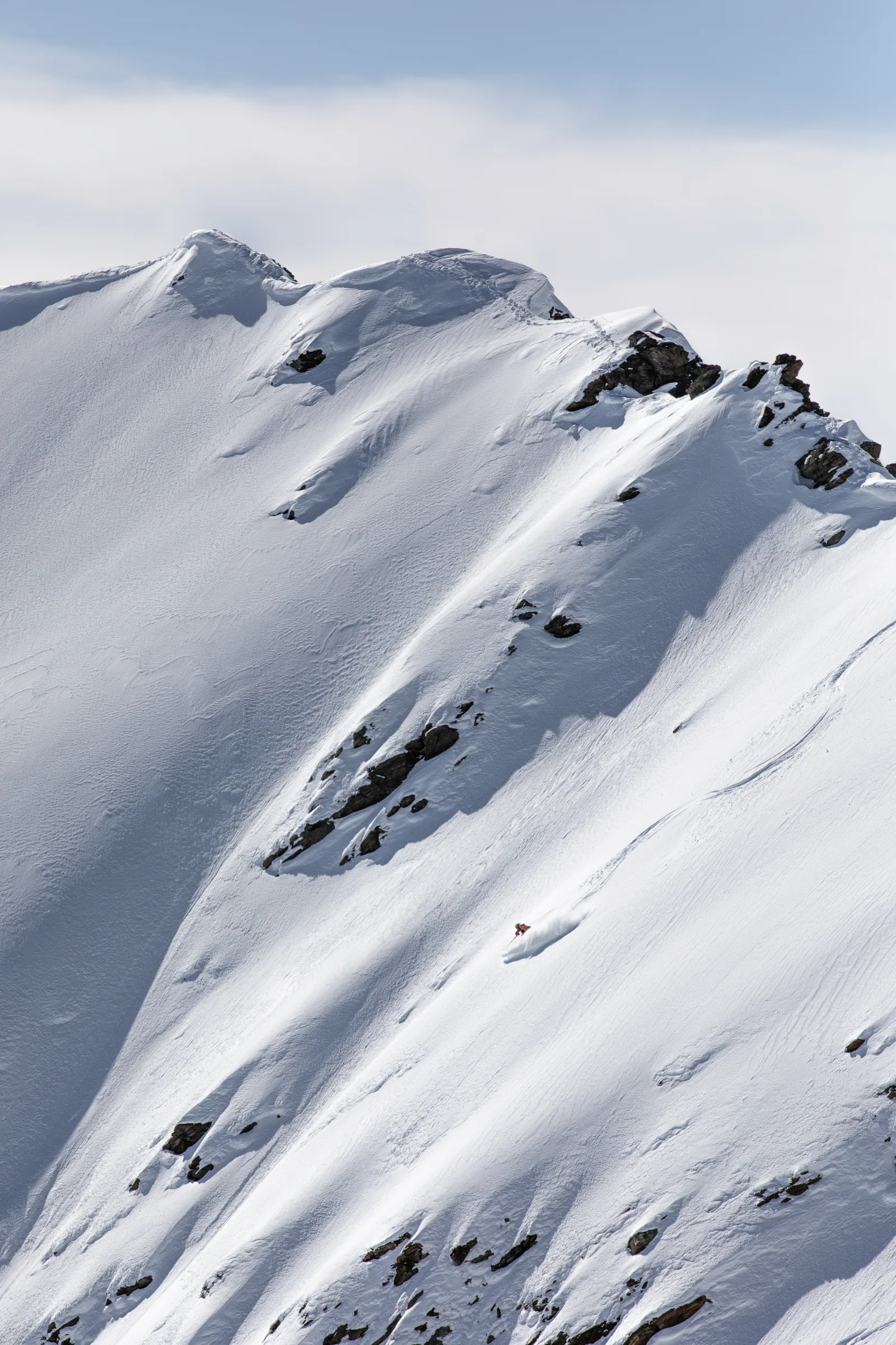 Snow-covered mountain ridges with rocky faces and ski tracks in Lenzerheide, photographed for Andrea Limbacher’s 2025 gallery.