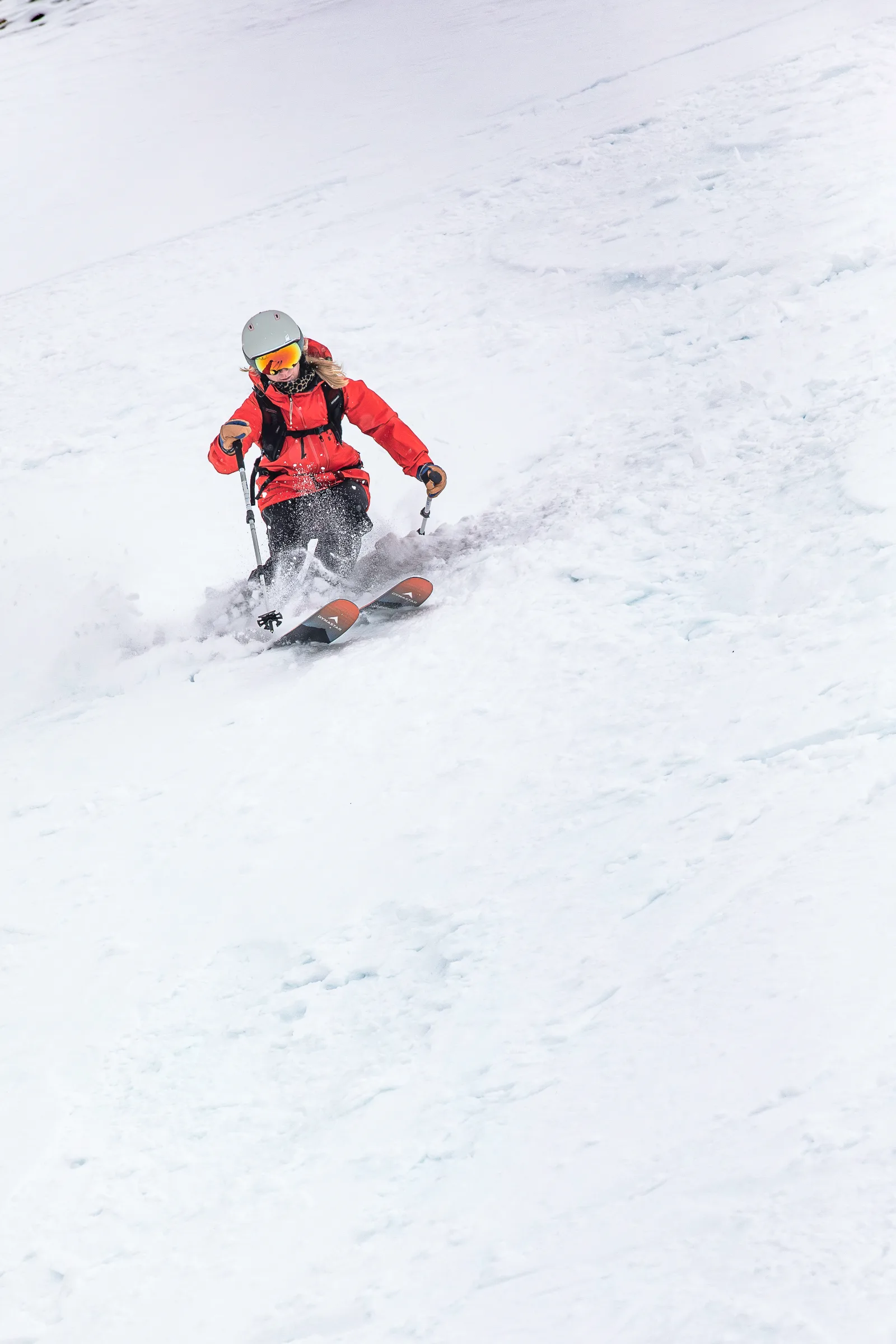 Pia Vogt skis toward the camera on an open snowy slope, kicking up snow around her ski tips.