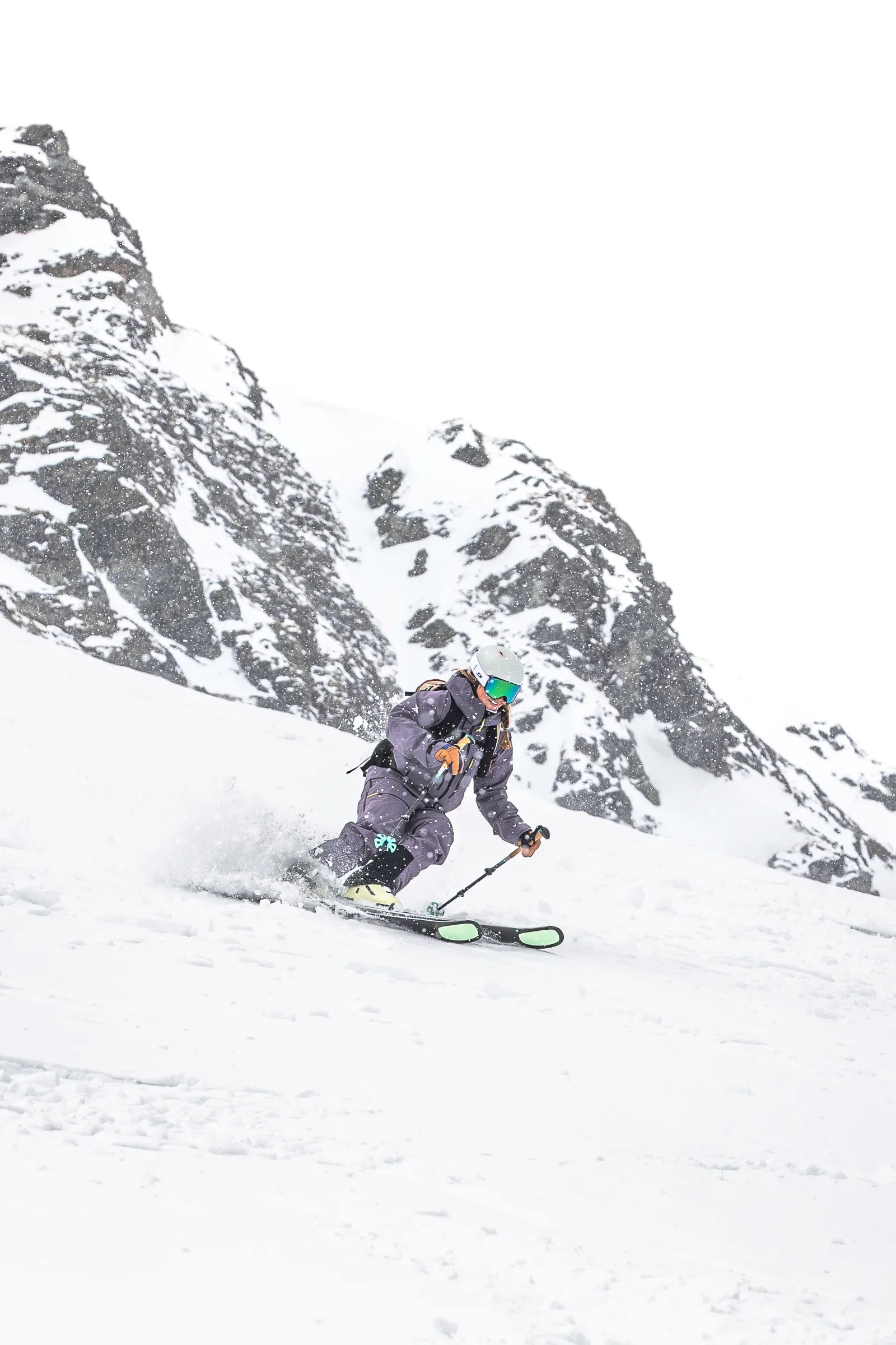 Ramona Arendt makes a turn on an open snowy slope in Lenzerheide beneath steep, snow-covered rock faces.