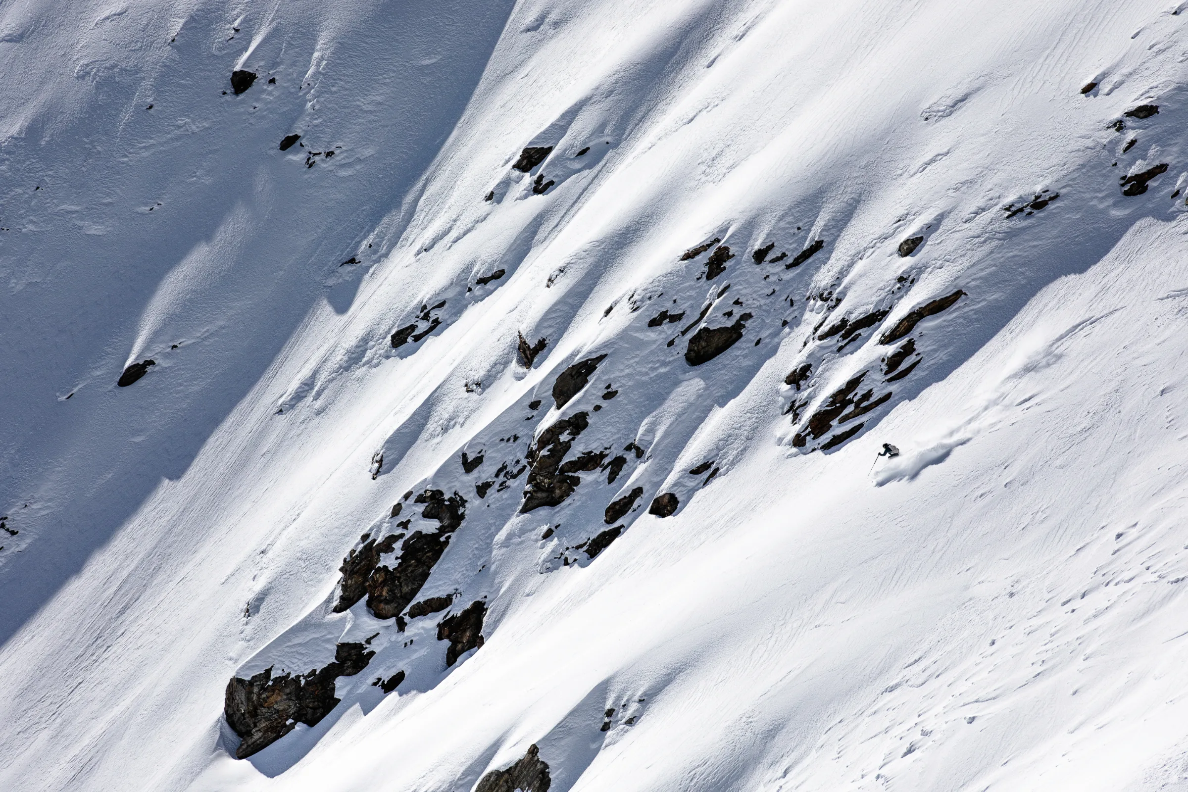 Simon Stickl makes a turn on a steep, rock-studded snow slope in Lenzerheide, throwing up a cloud of powder.